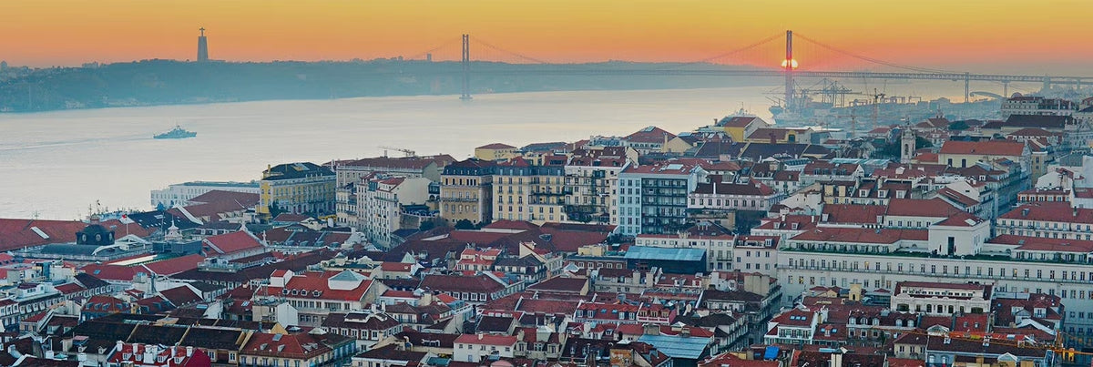Stunning sunset view over Lisbon, showcasing the city rooftops and the iconic bridge, perfect for insider tips for visiting Lisbon.