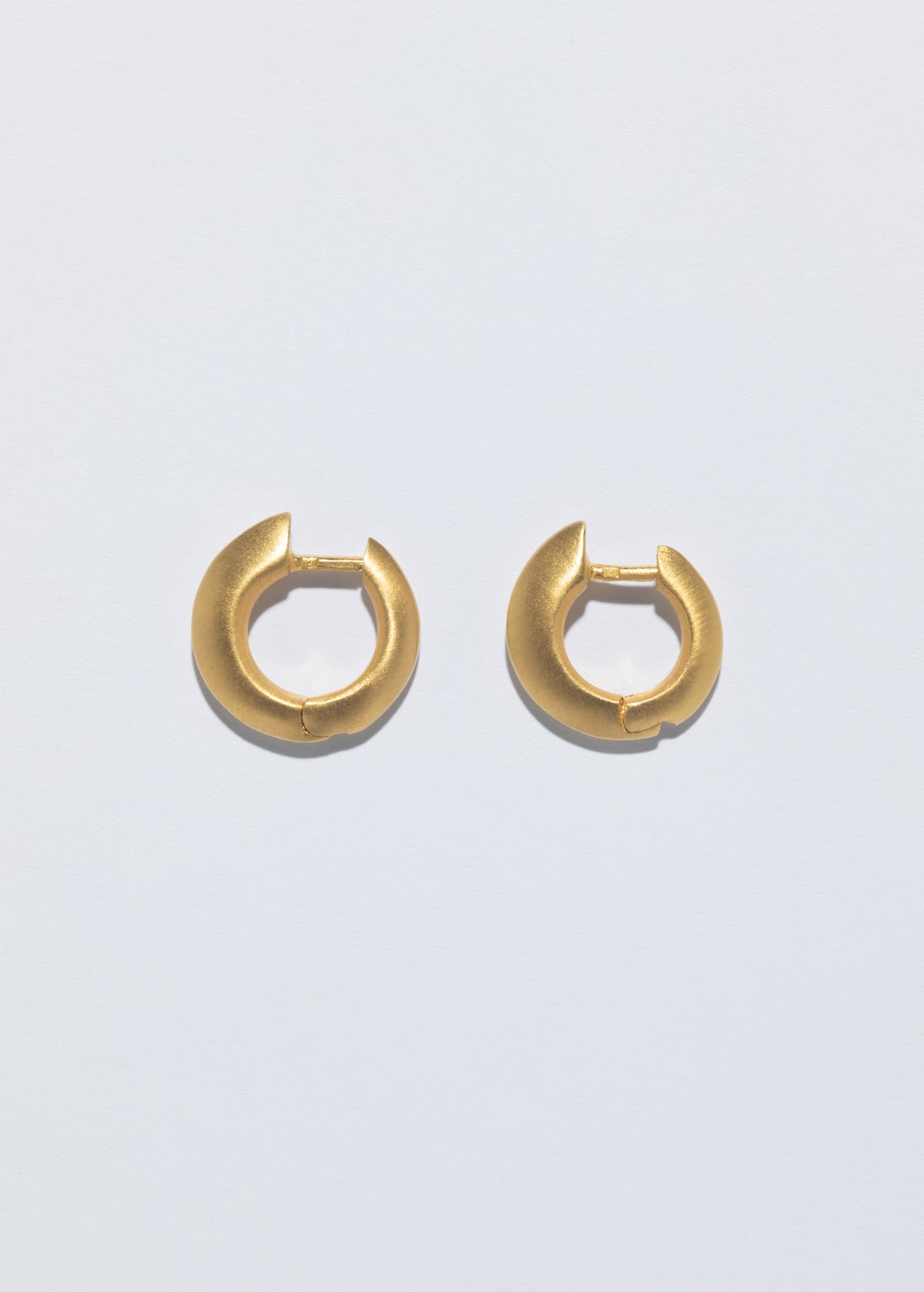 Gold hoop earrings from the symbolic jewelry gifts collection by CINCO.