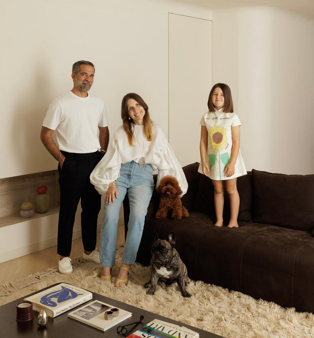 Familia de tres personas con dos perros en una sala de estar