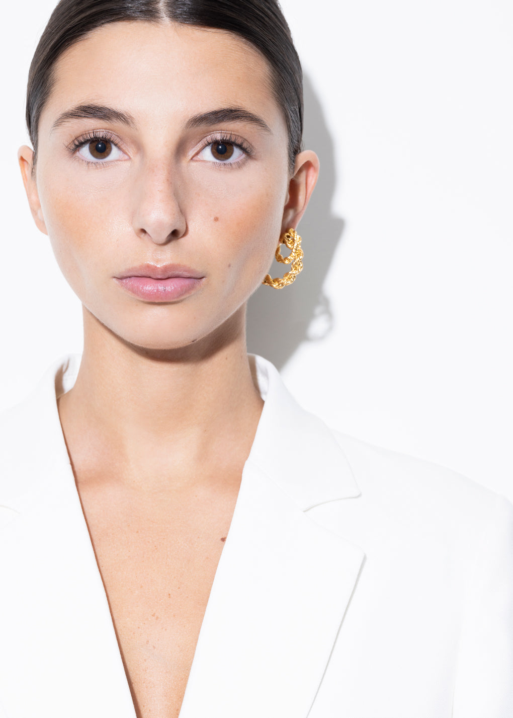 model wearing bia earrings and mini bia earrings in gold