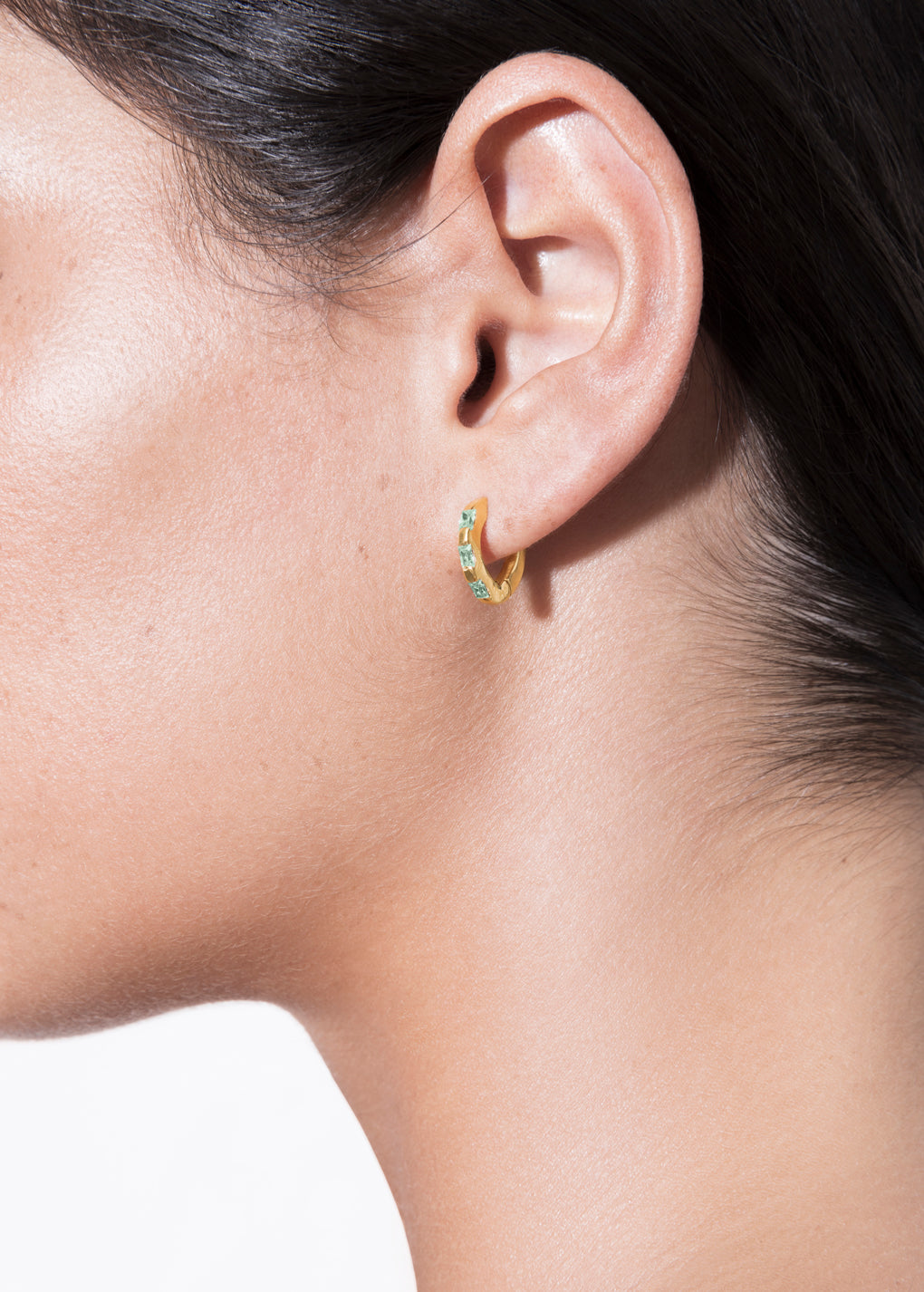 model wearing norma earrings emerald in gold